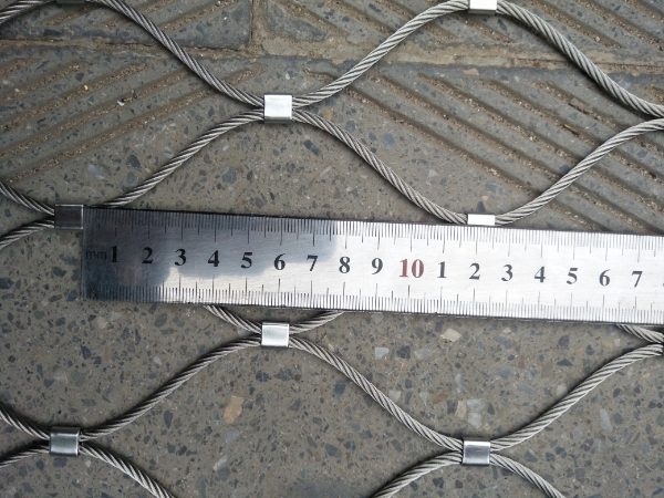 A ruler is used to check the wire rope mesh aperture length.