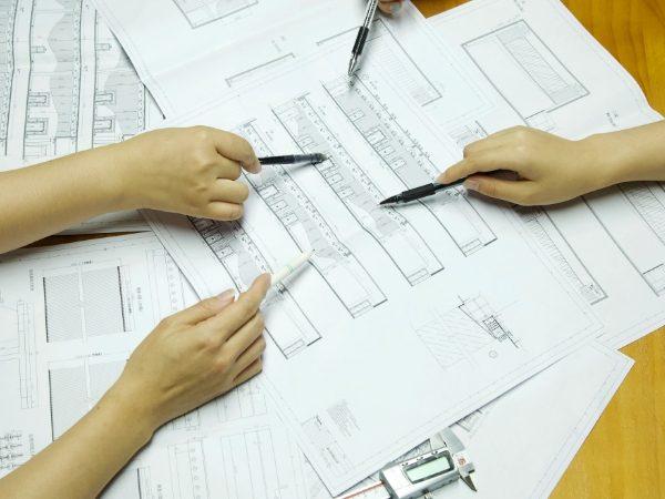 4 Mitglieder diskutieren die Zeichnungen.