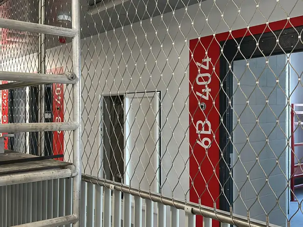 Workers are installing the frame rope mesh system.