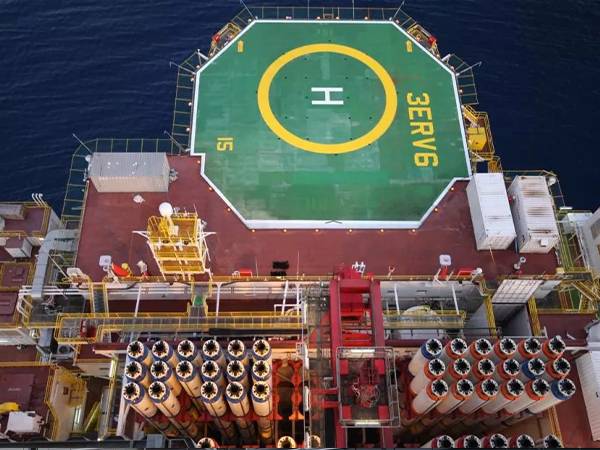 Green offshore helipad surrounding is encircled with helideck safety net.