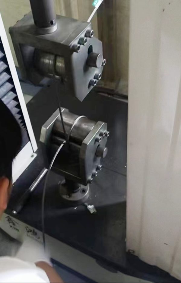 The machine is carrying out wire rope mesh tensile strength test.